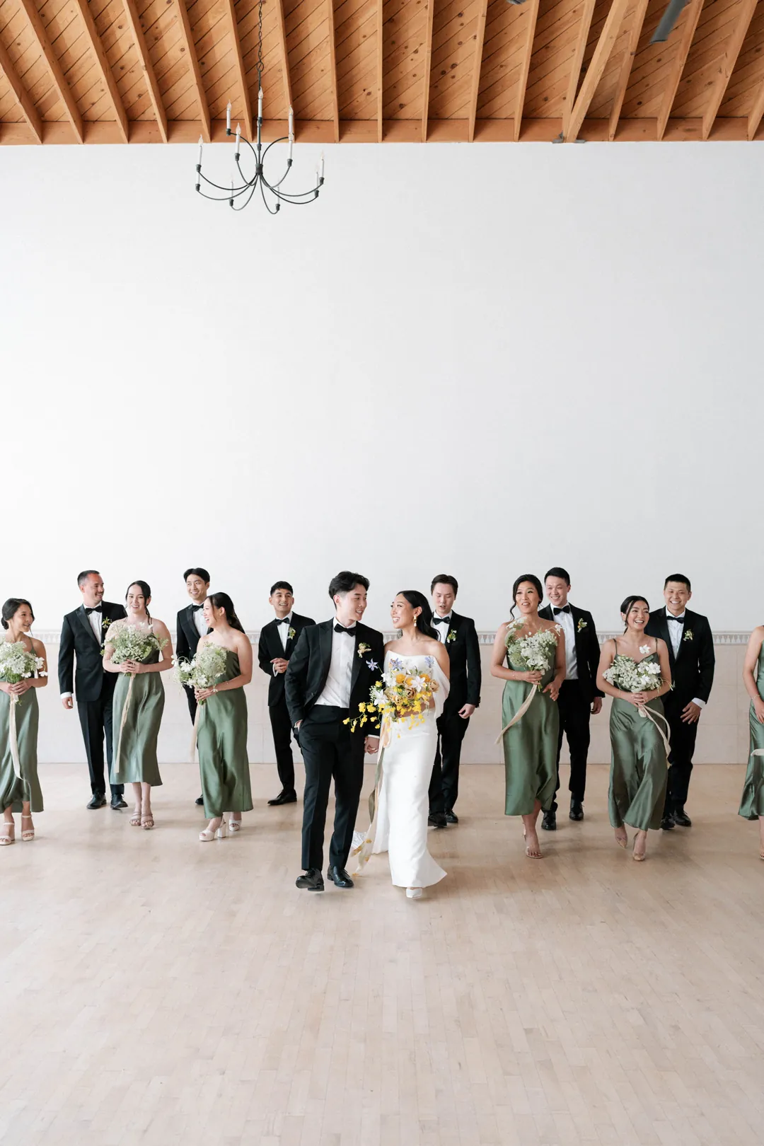 Wedding party posing together in a bright room