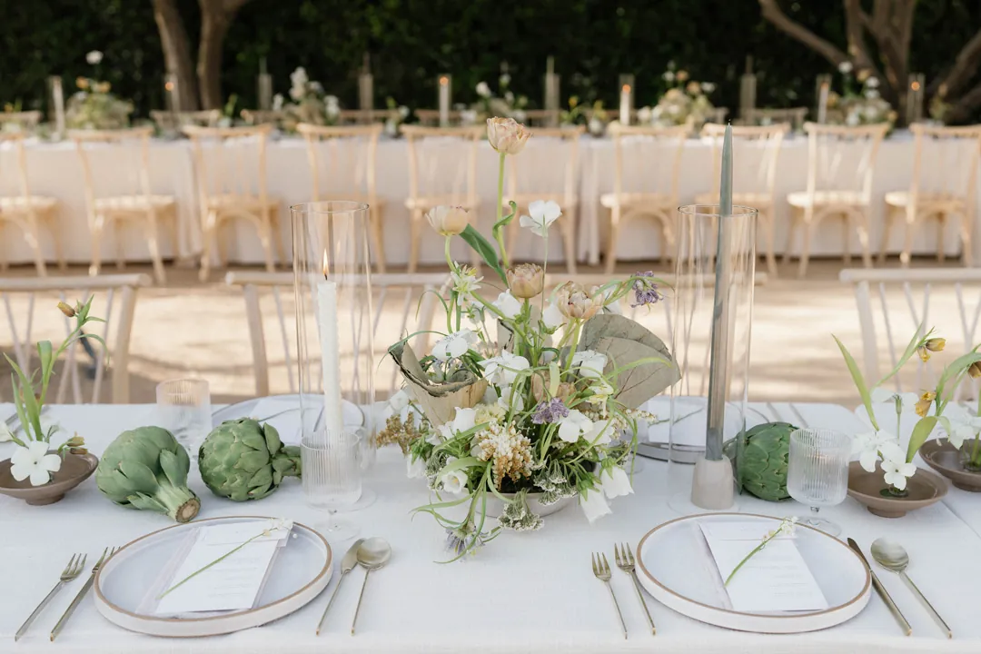 White place settings with green napkins and pale flowers