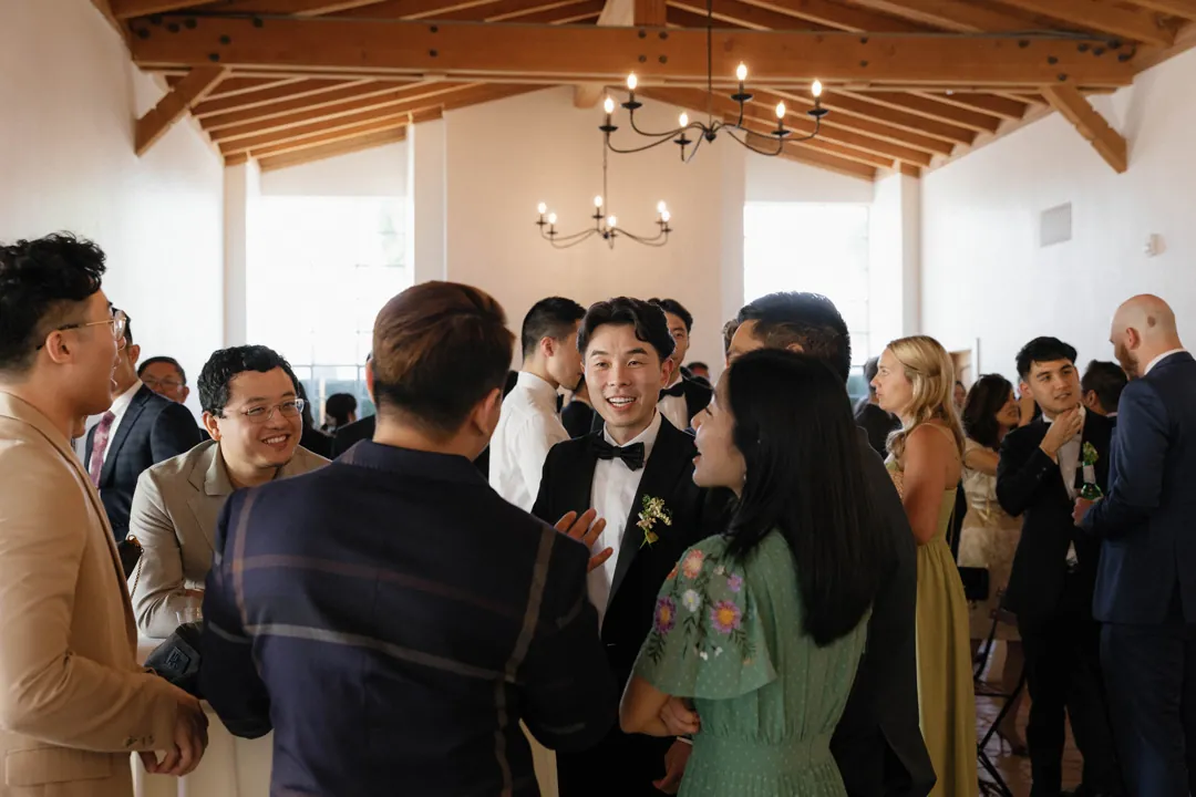 Wedding guests talking together inside the reception hall