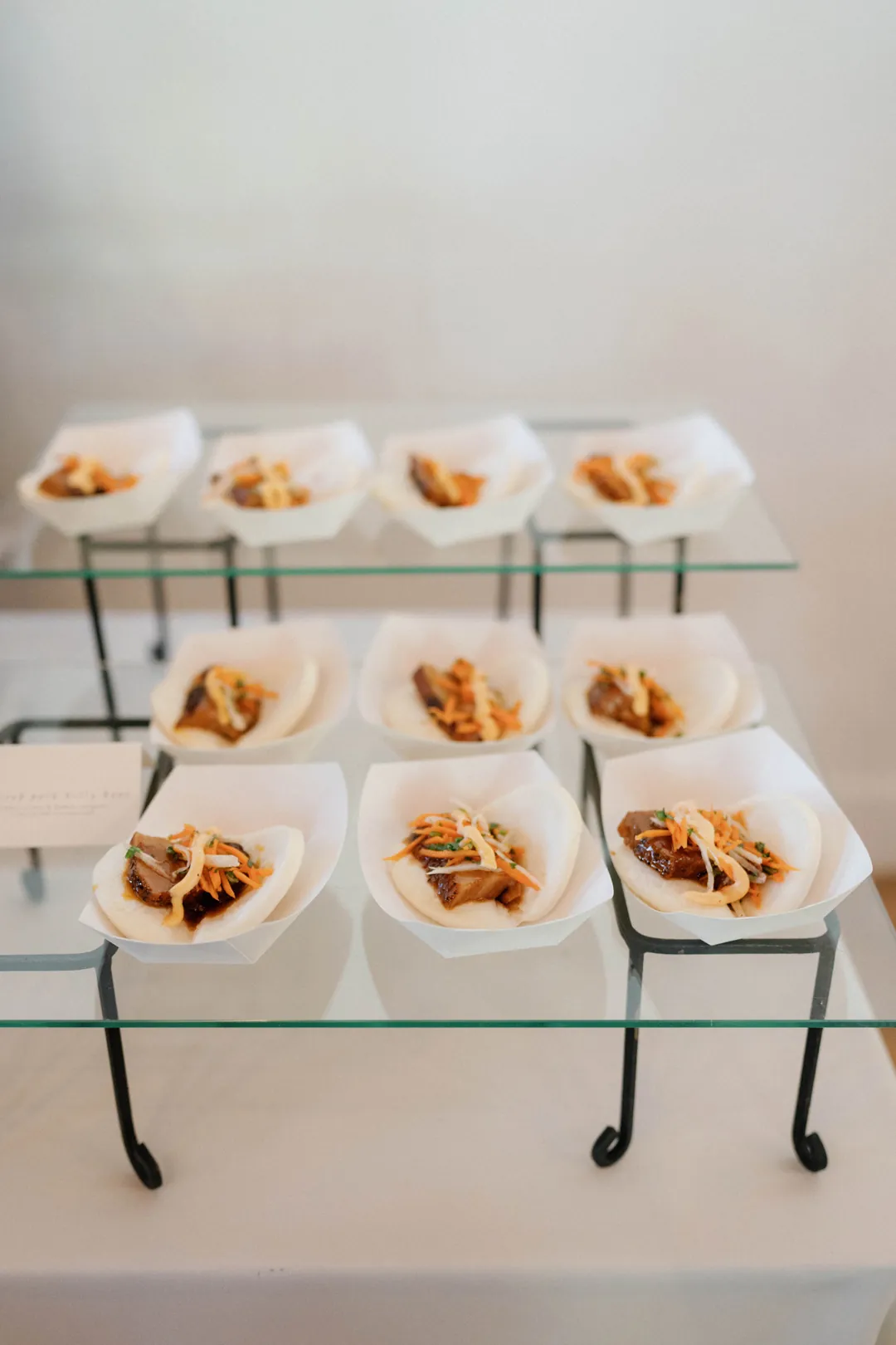 Small appetizers arranged on tiered white serving trays