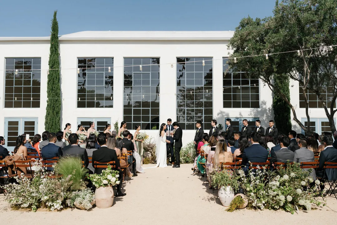 Guests seated outside the reception hall for a wedding ceremony