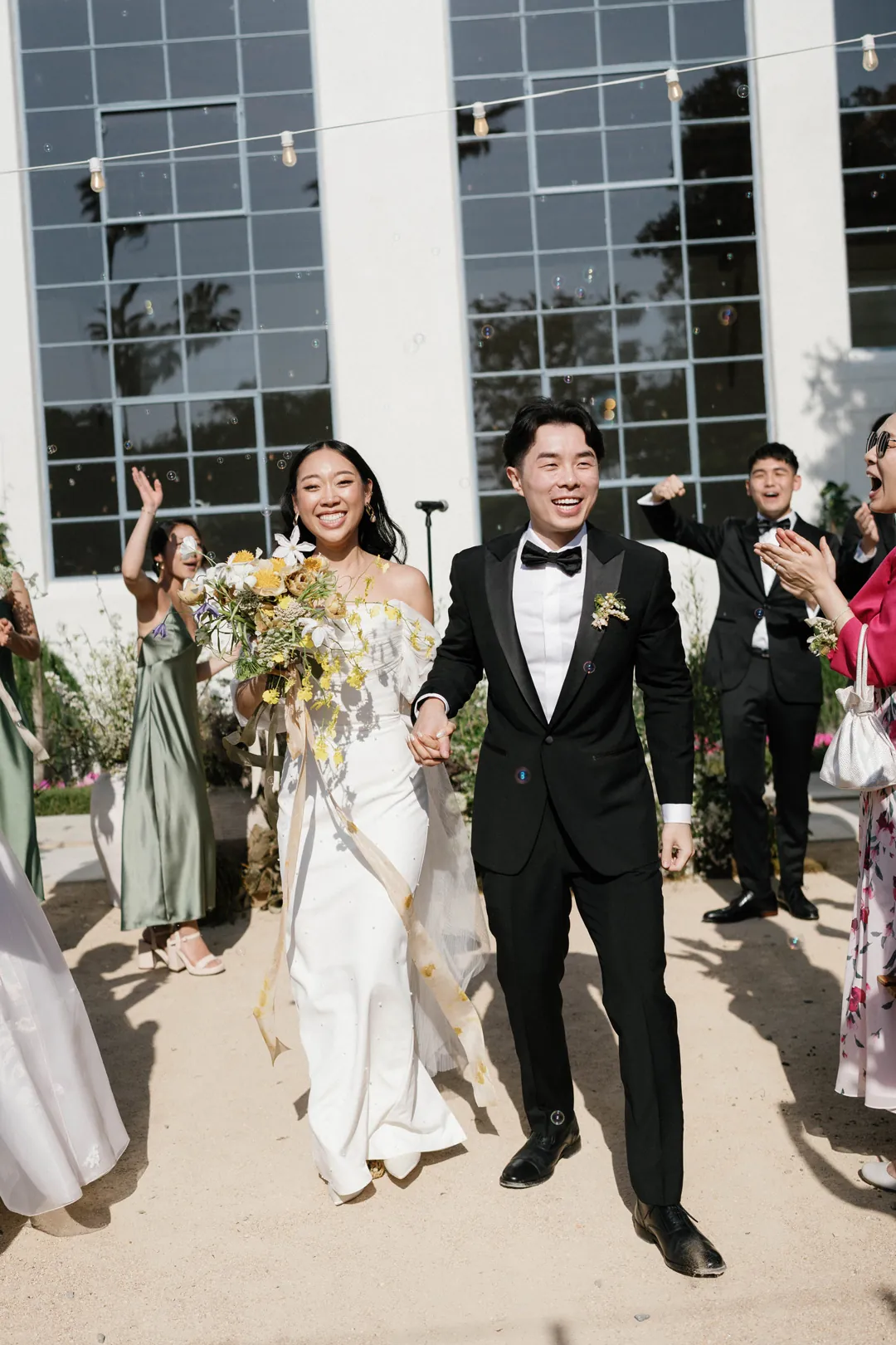 Newlyweds walking down the aisle beside their wedding guests