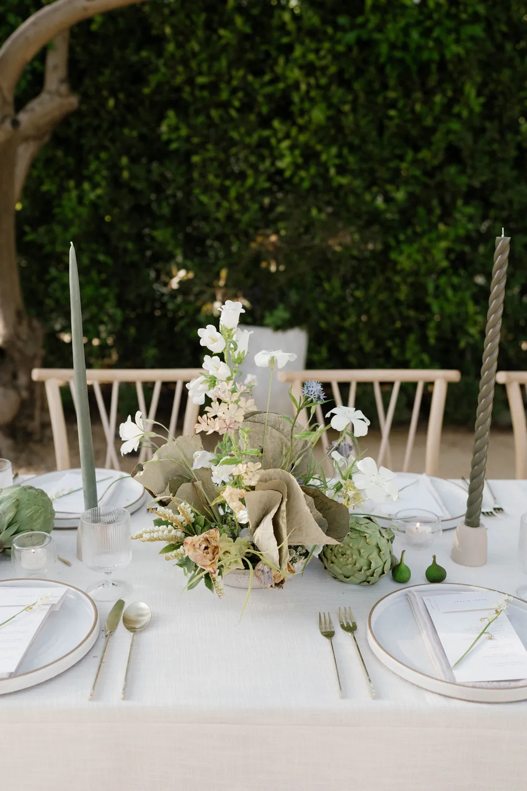 White flowers and greenery at an outdoor dining table