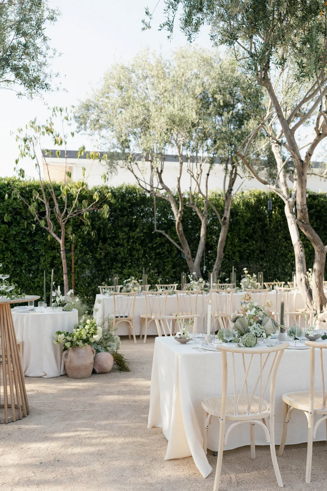 Round courtyard reception tables decorated with white flowers