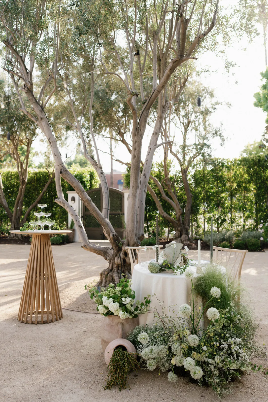 Sweetheart table framed by low white floral arrangements