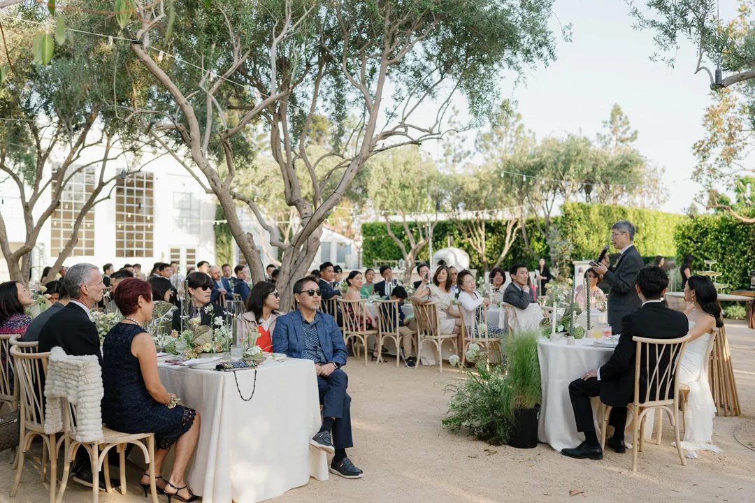 Guests seated at round reception tables in the courtyard