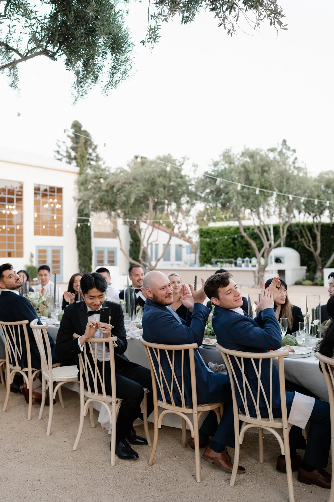 Guests enjoying the outdoor reception among courtyard trees