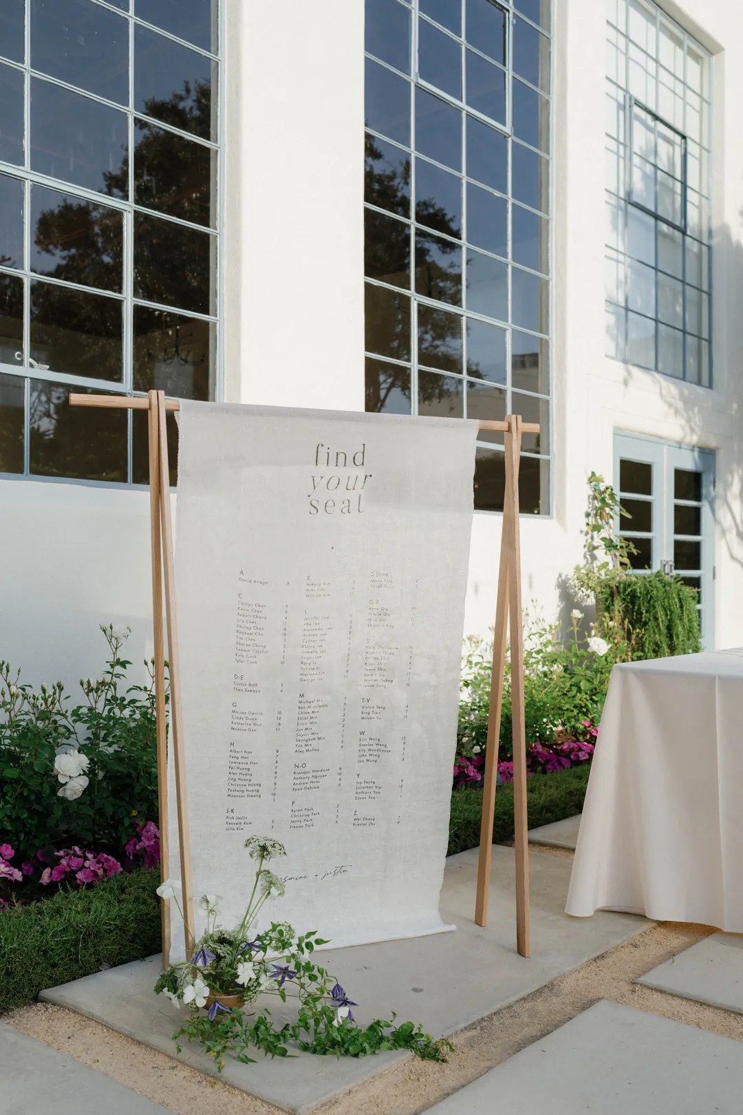 Wedding seating chart framed by a wooden stand and flowers