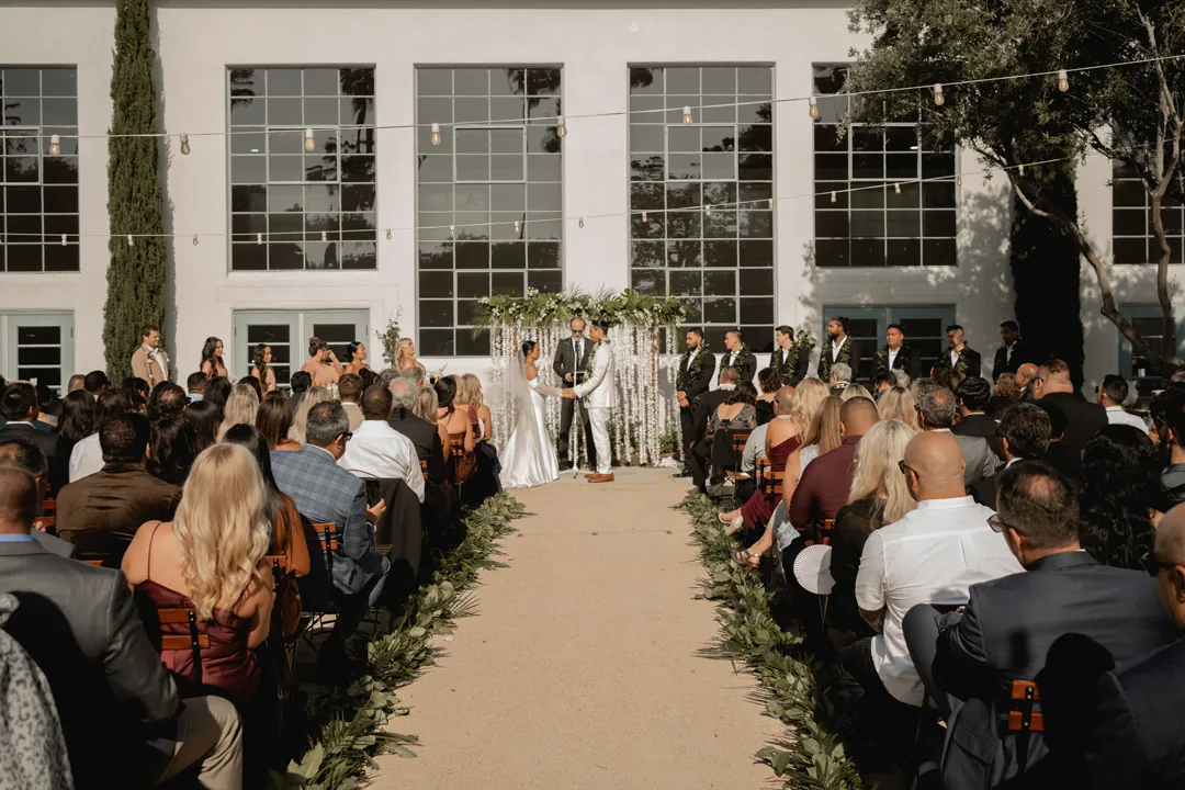 Guests seated along the courtyard ceremony aisle