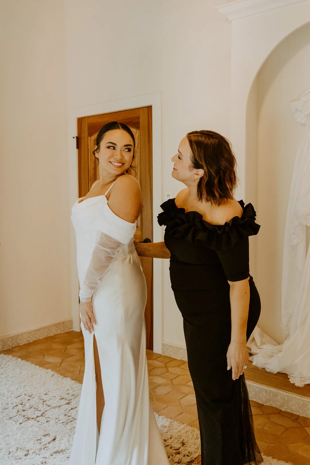Bride posing beside a woman in a black dress