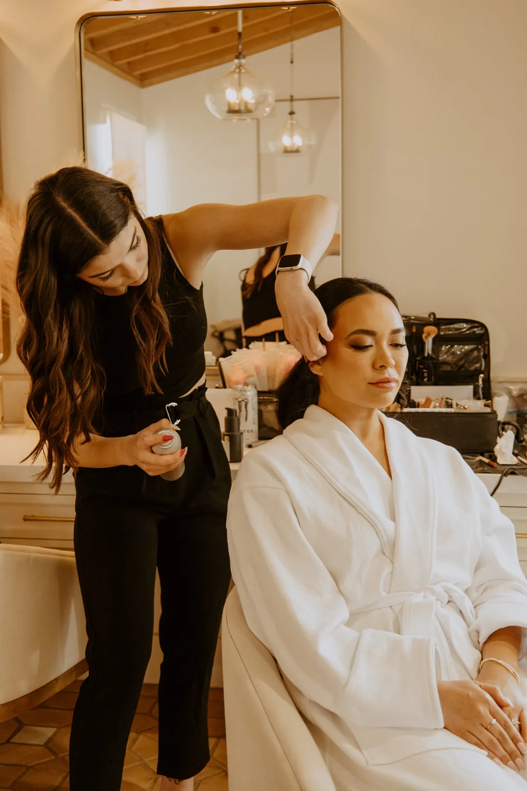 Stylist arranging the bride’s hair in the lounge
