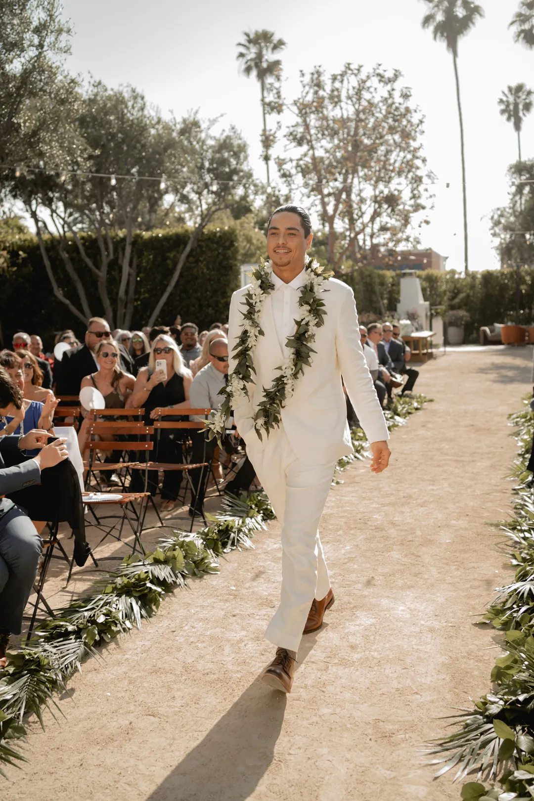 Groom walking down the outdoor ceremony aisle
