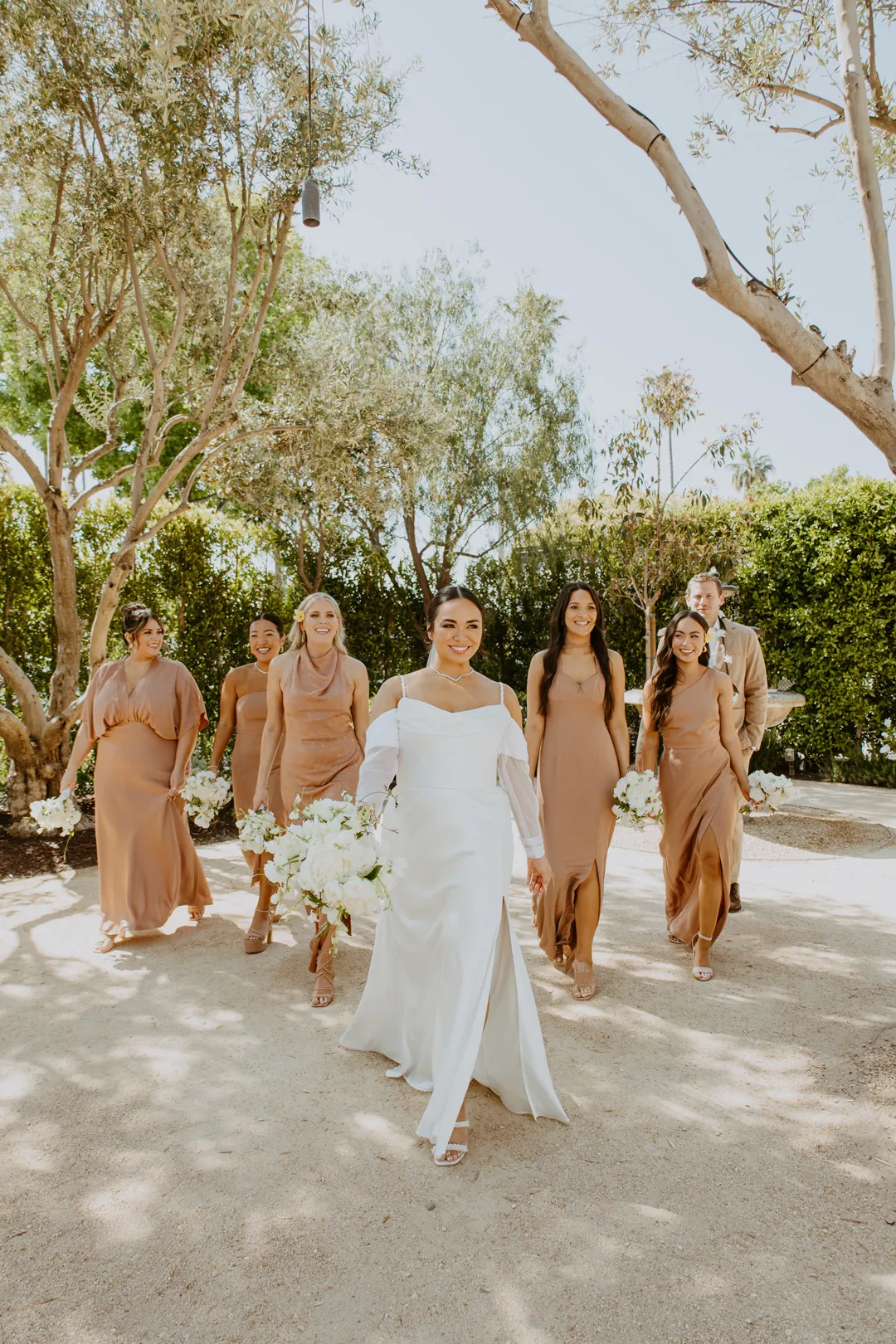 Bride and bridesmaids walking through the courtyard