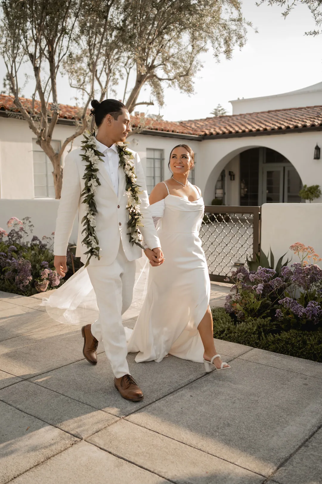 Bride and groom walking together through the courtyard