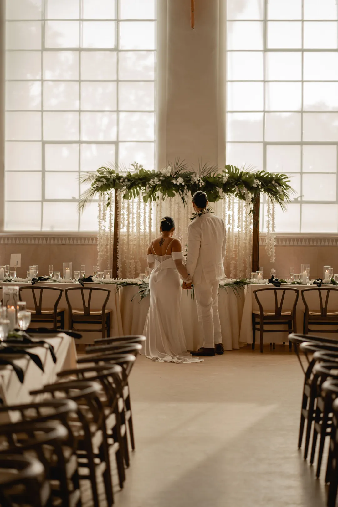 Flower-covered backdrop behind the reception sweetheart table