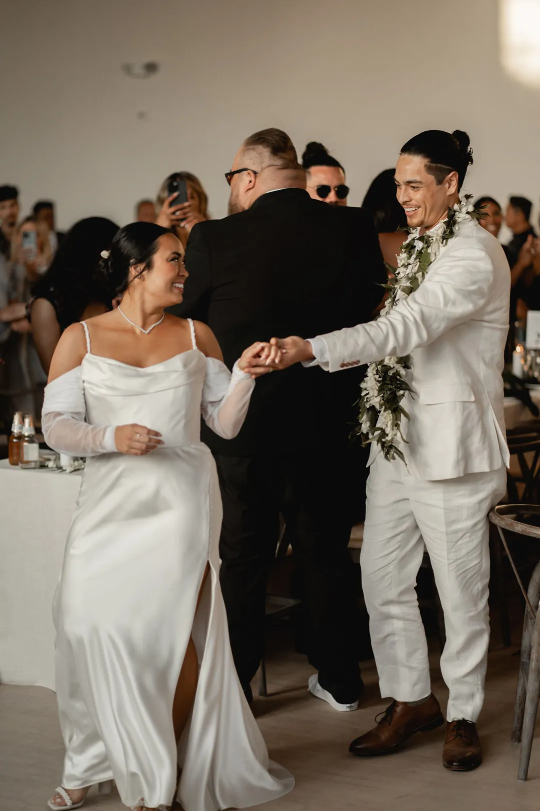Bride and groom entering the reception beside the DJ