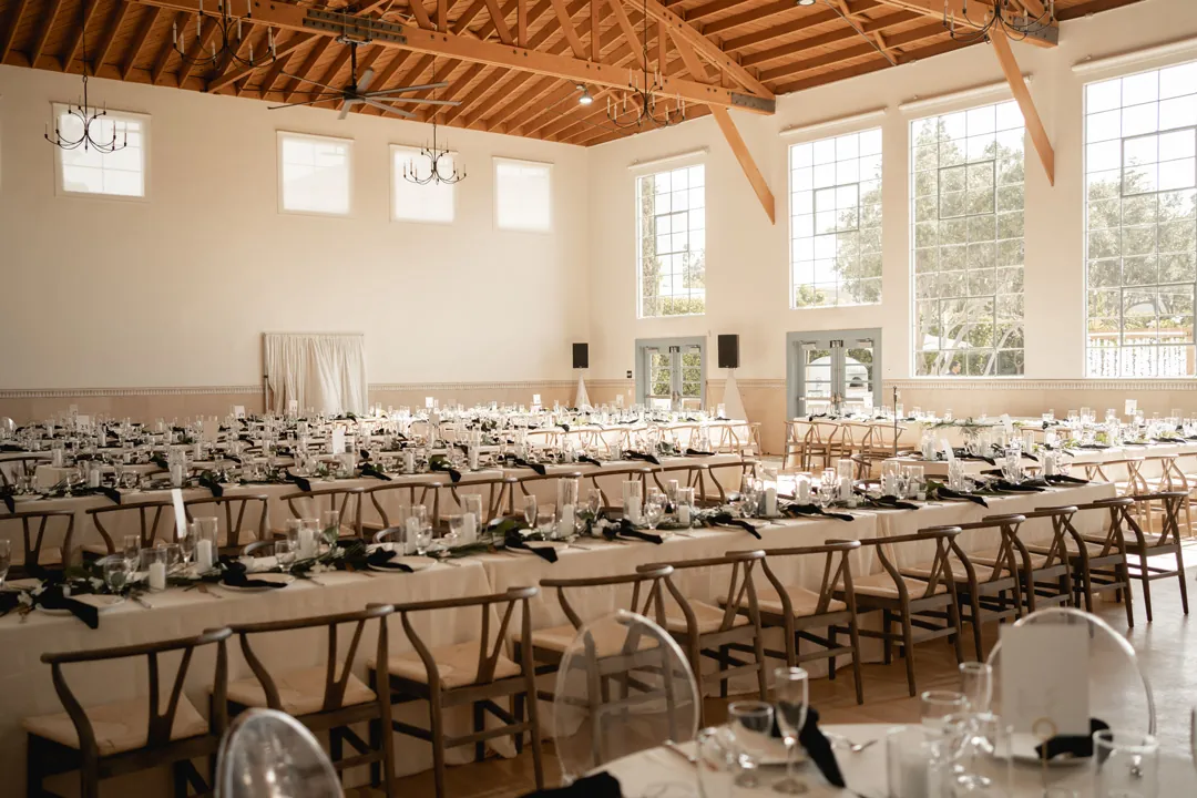 Reception tables set beneath the exposed wood ceiling