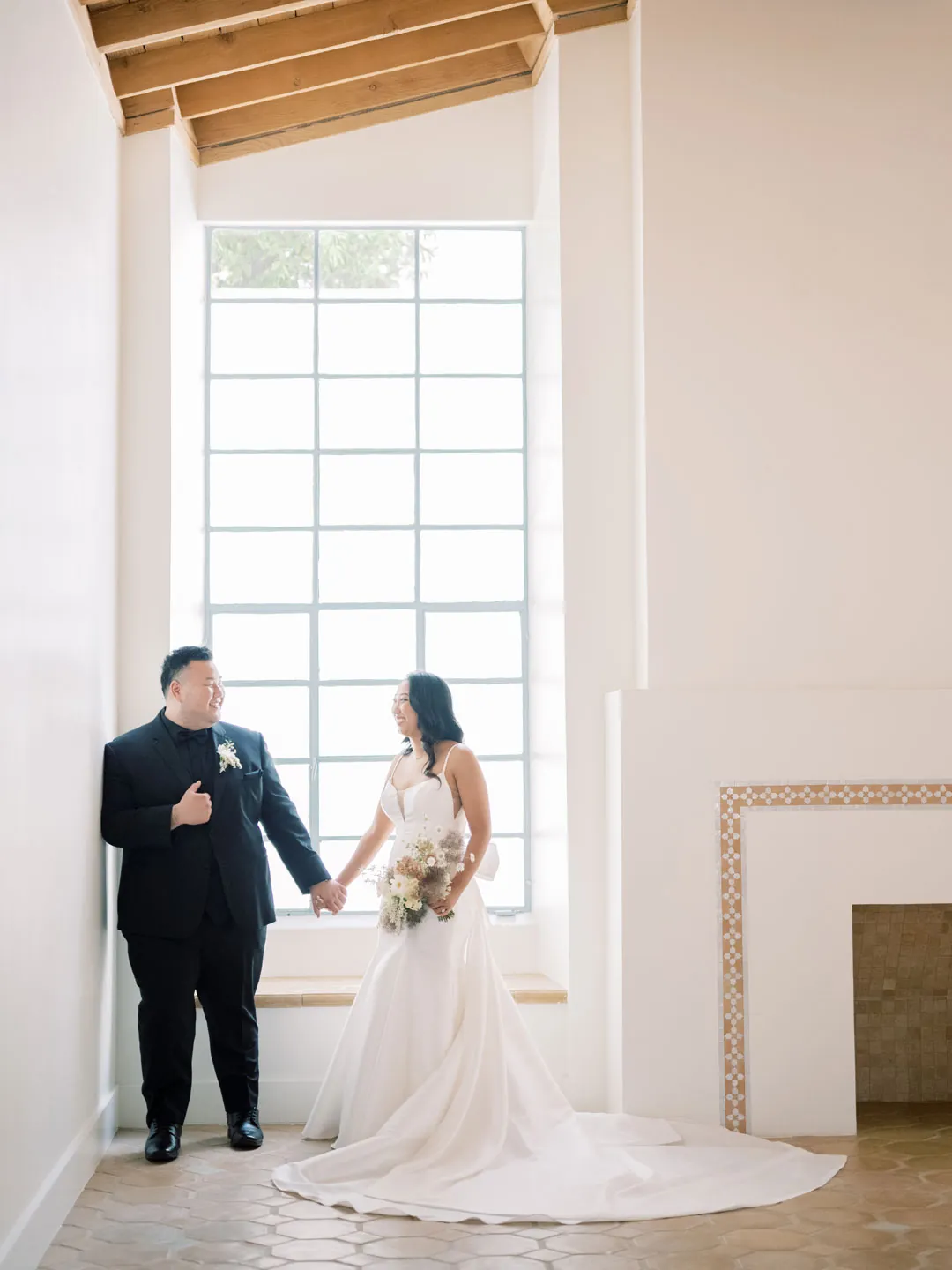 The couple stands together beneath the courtyard ceiling.