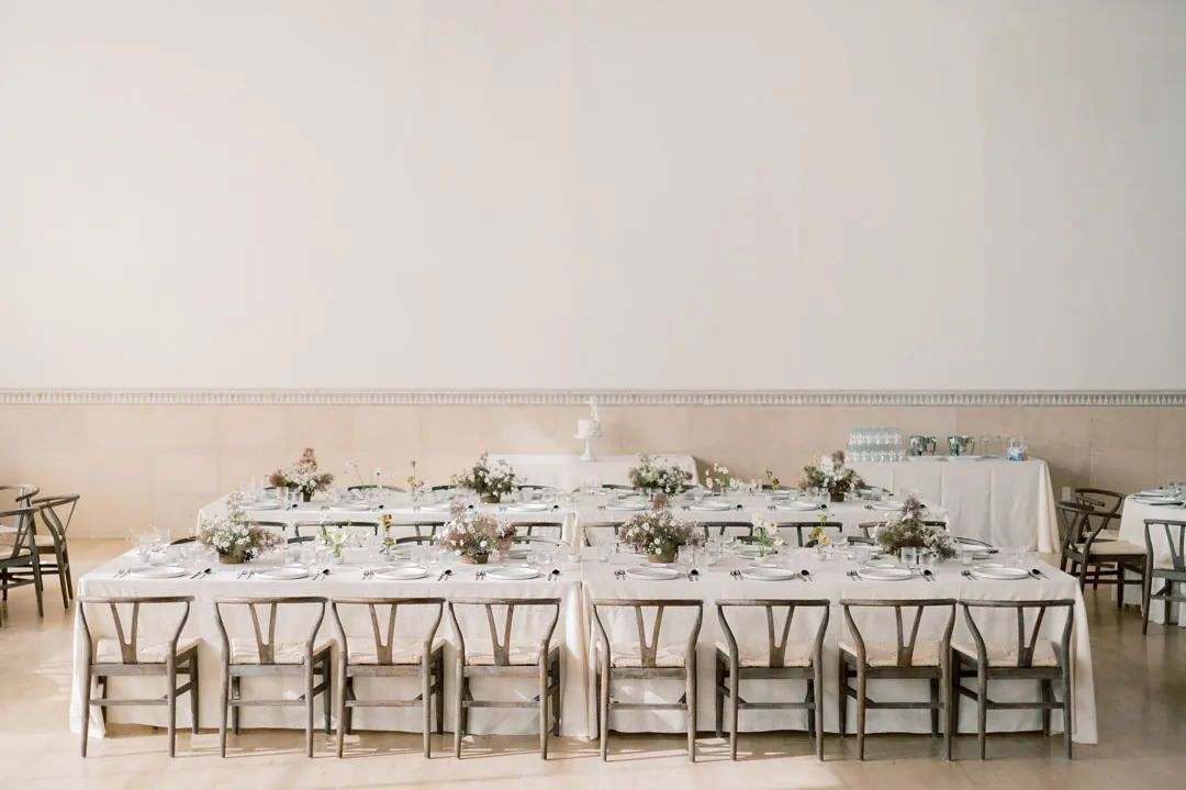 Long reception dining table with pale floral centerpieces