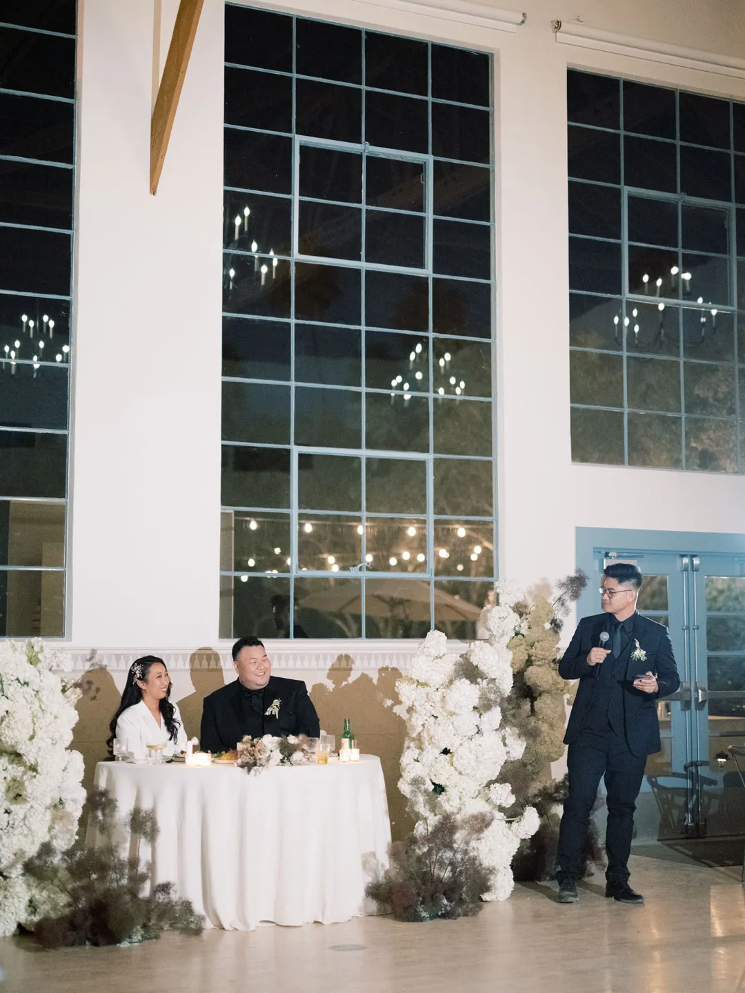 Guest giving a toast beside the couple's sweetheart table