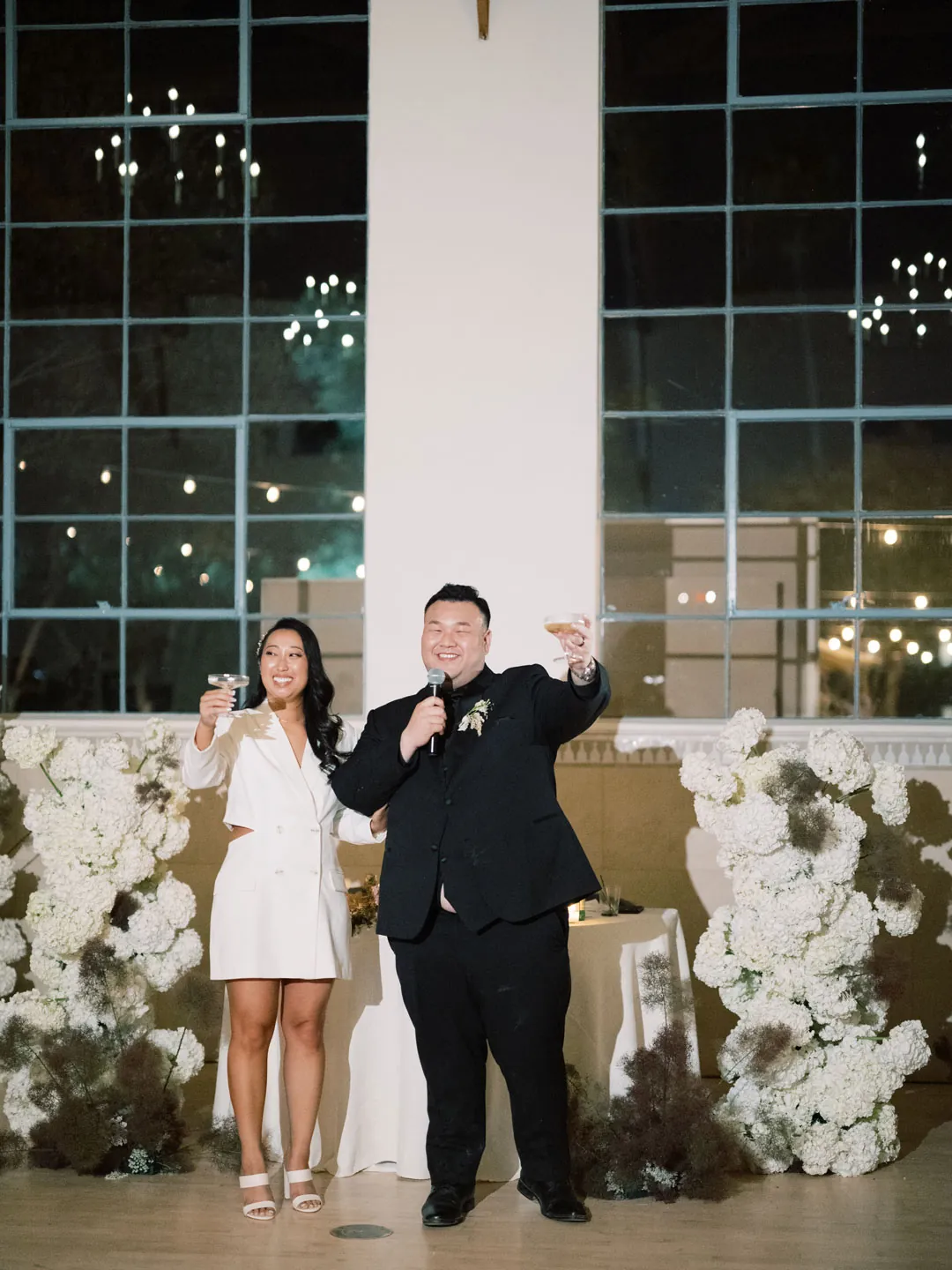 Bride and groom speaking into microphones at the reception
