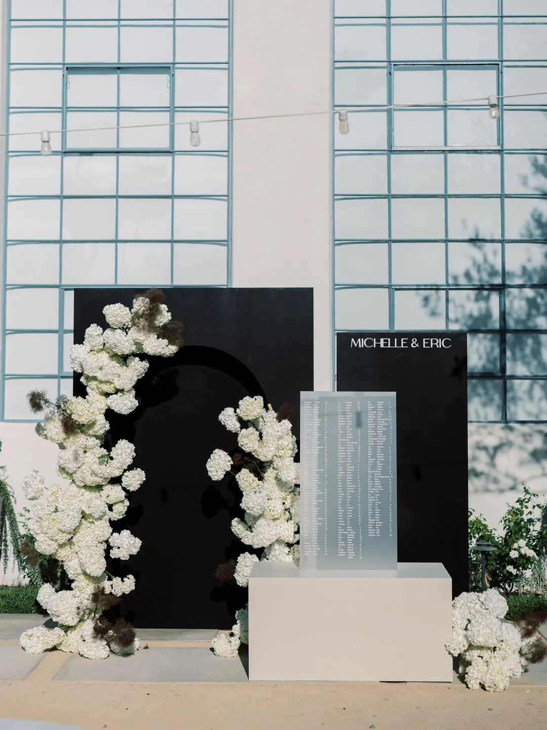 White flowers framing a black wedding display indoors