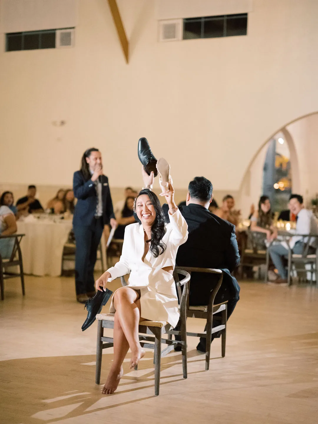 Bride and groom seated back to back for a reception game
