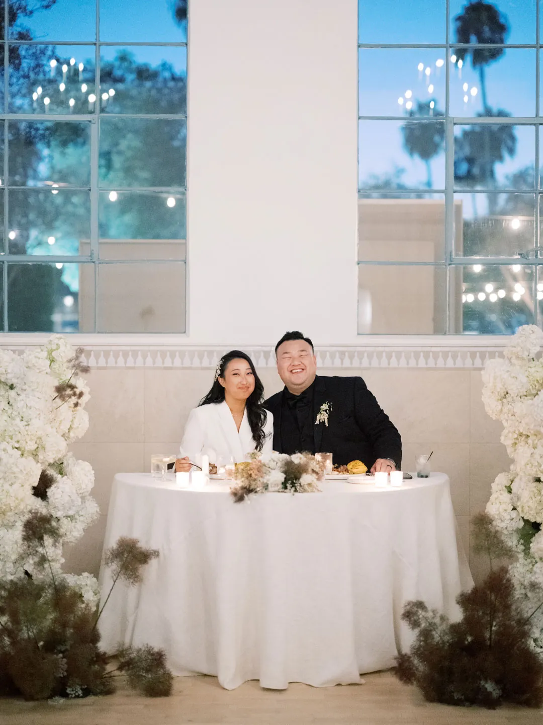 Couple seated together behind their sweetheart table