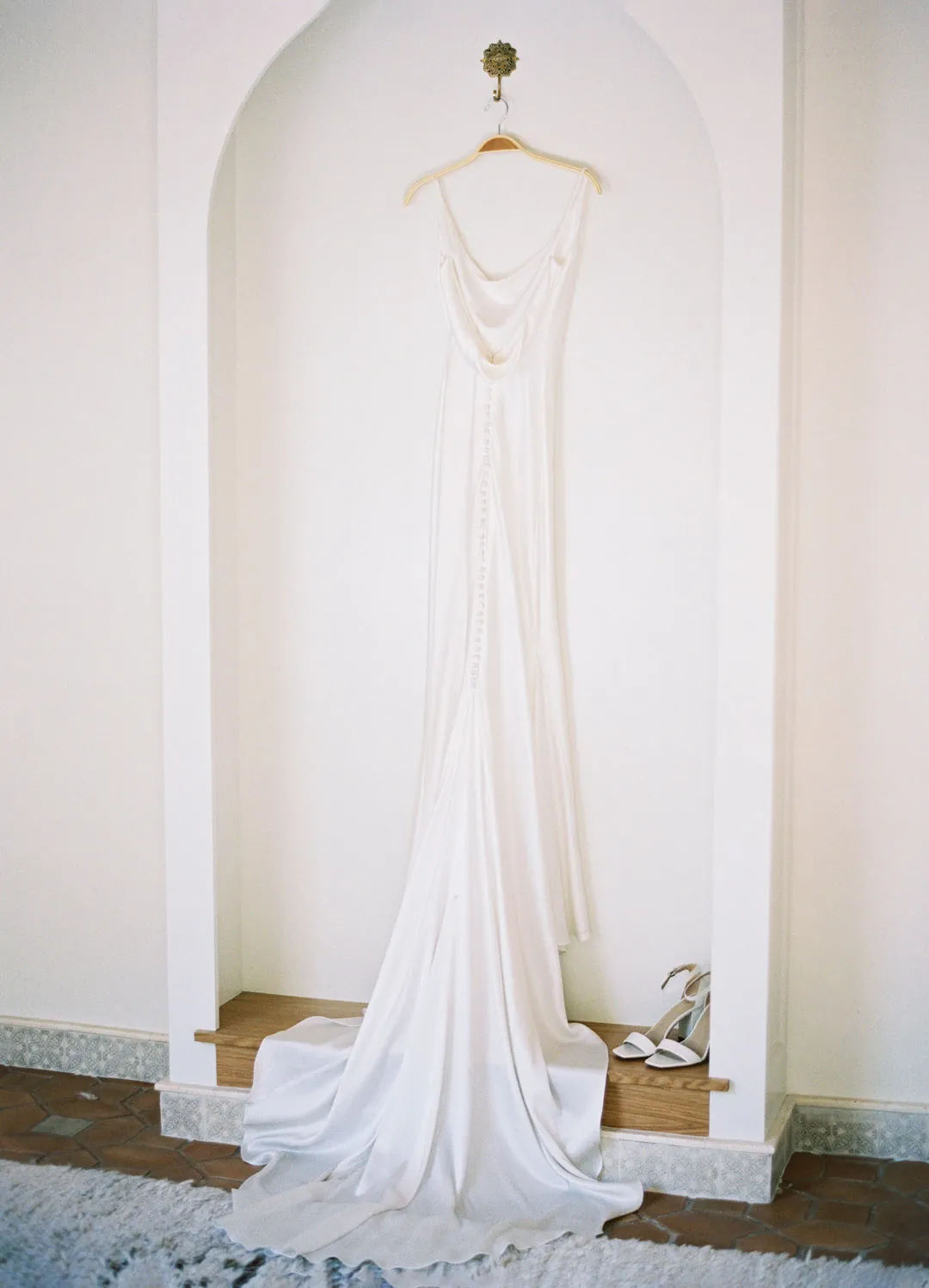 Wedding dress hanging in a recessed wall niche