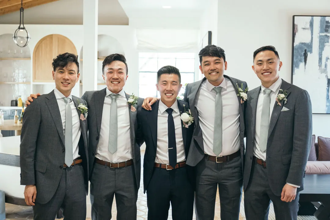 Groom and groomsmen posing together with arms around shoulders