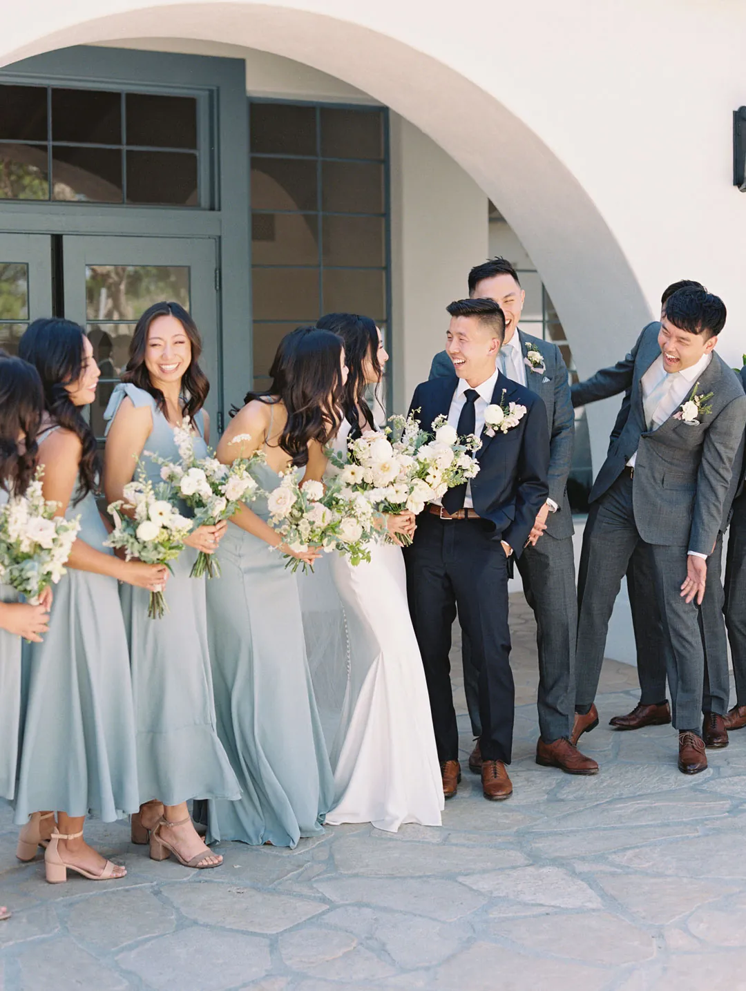 Wedding party posing together outside the reception hall