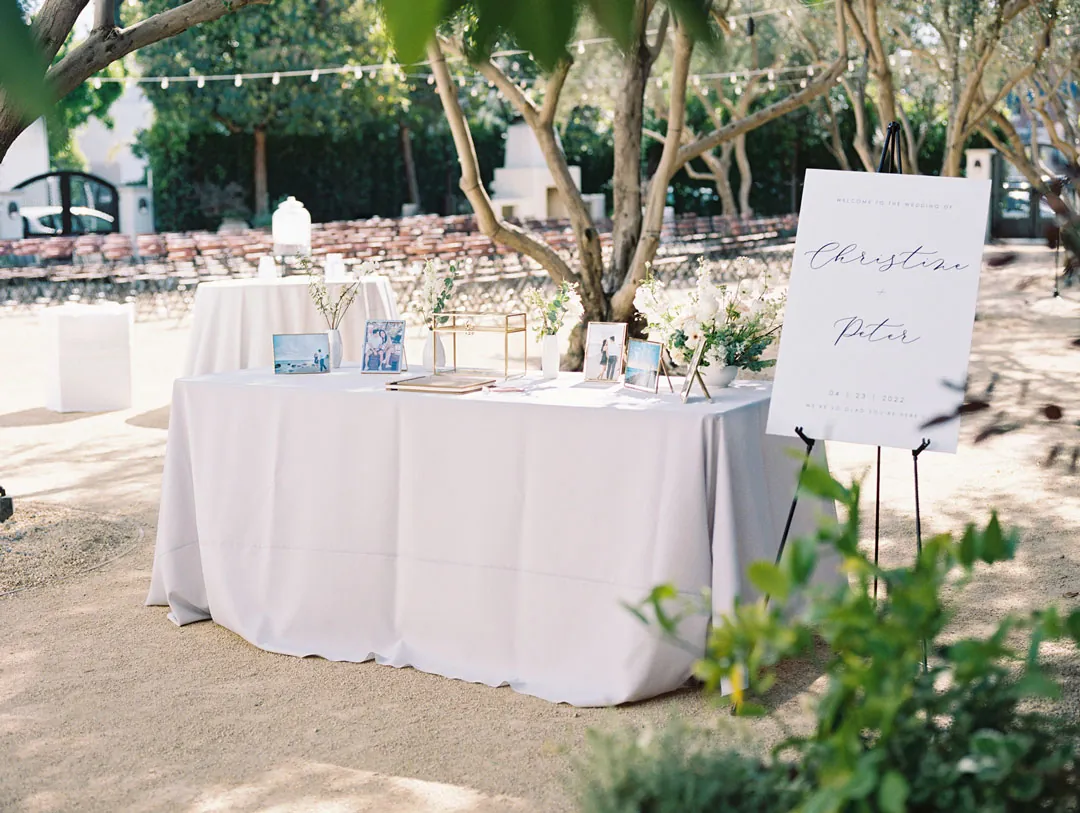 White guest table beside a wedding welcome sign