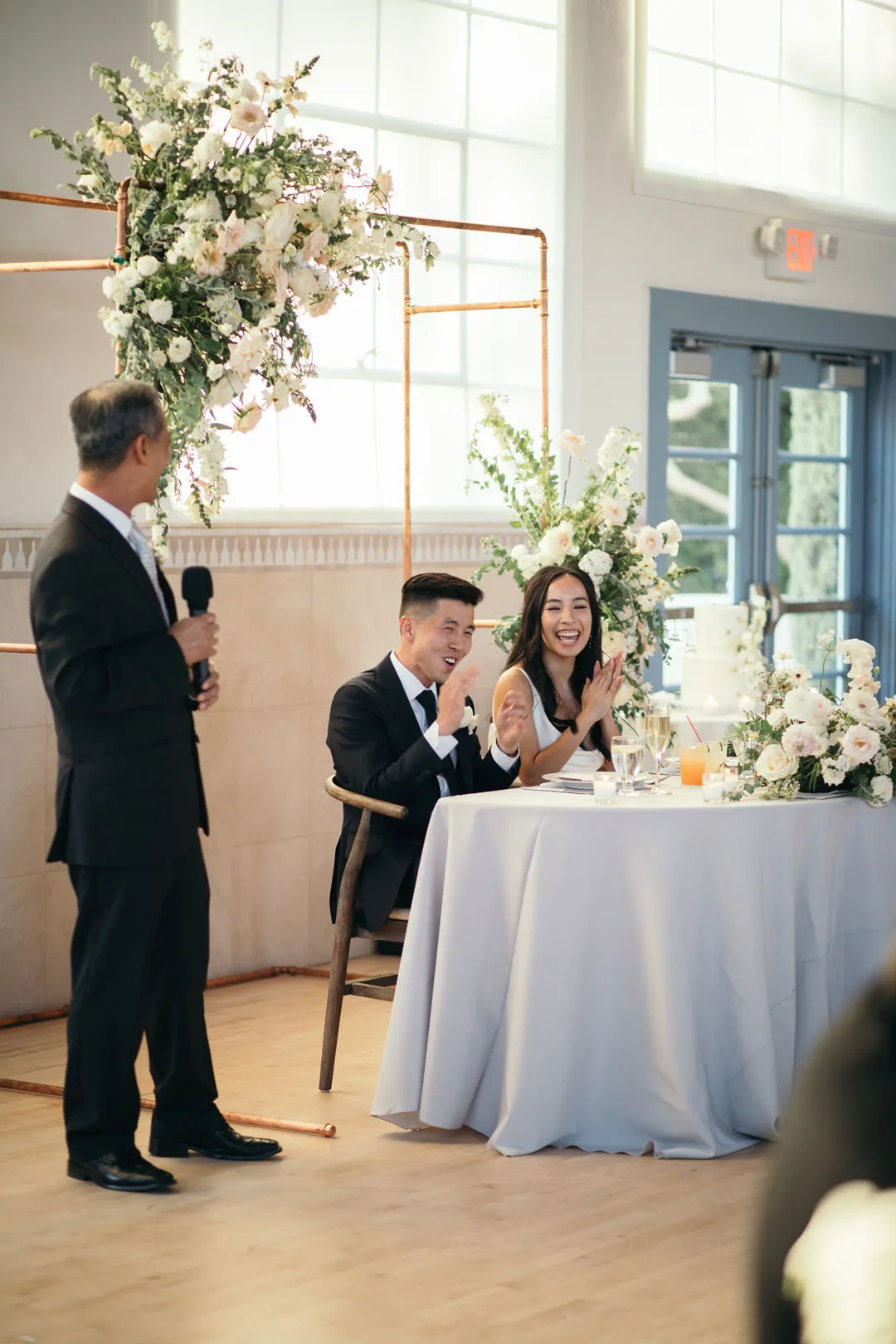 Guest giving a toast beside the newlyweds’ sweetheart table.