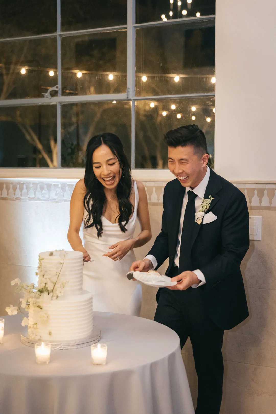 Newlyweds cutting their wedding cake together.