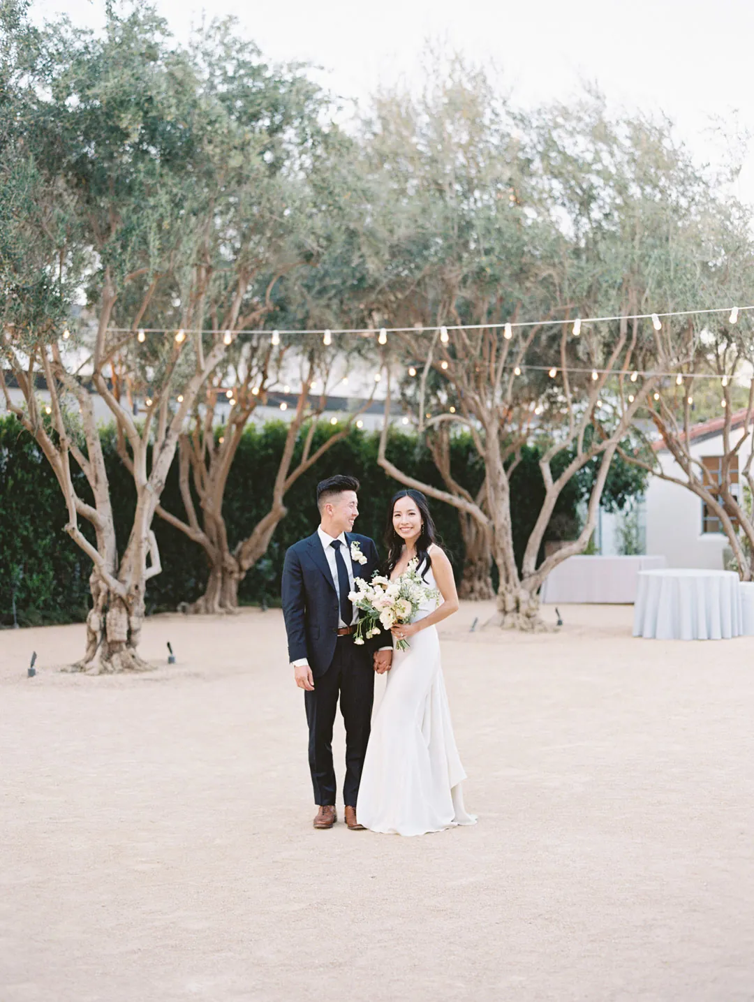 Bride and groom posing together in the courtyard