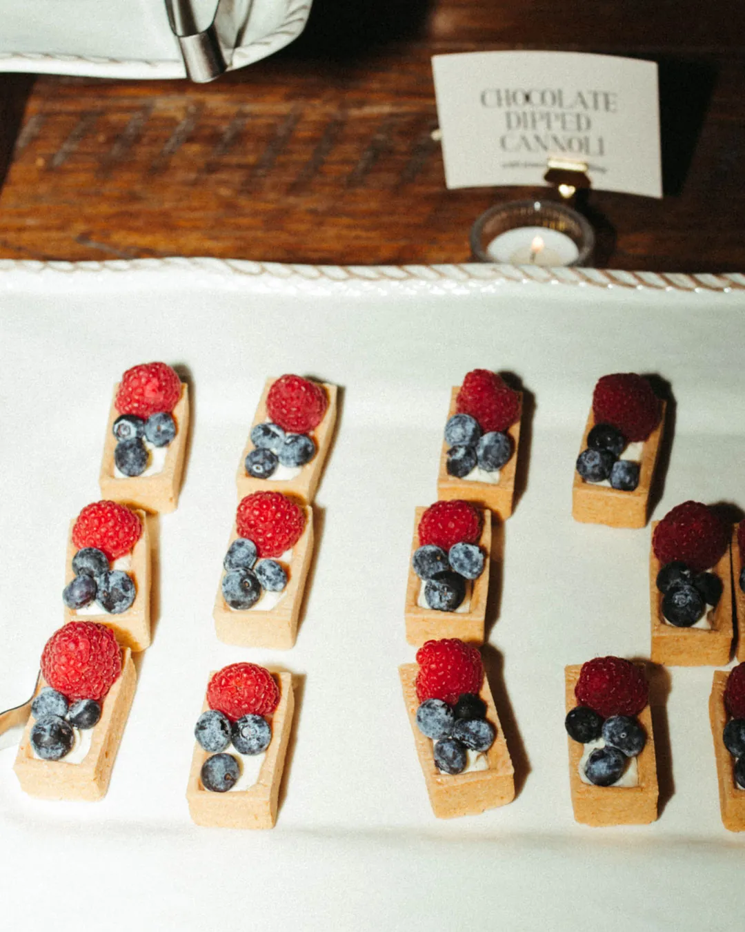 Berry-topped dessert bars on a white platter