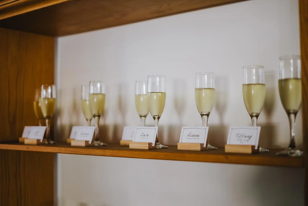 Stemmed tasting glasses arranged on a wooden shelf