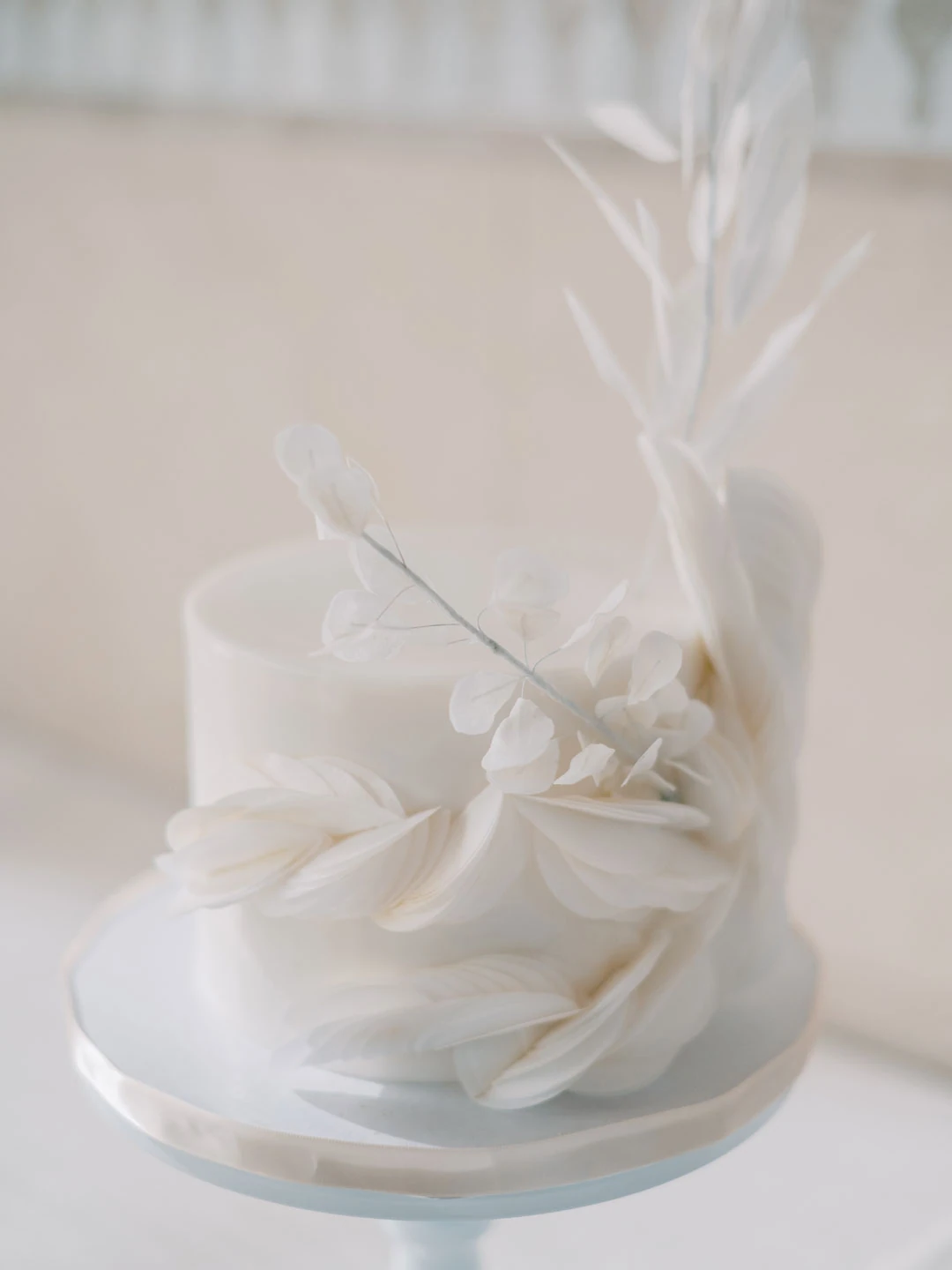 White cake decorated with sculpted petals and branches