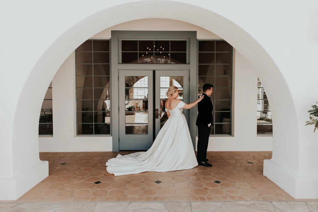 Newlyweds posing beneath the venue’s exterior arch.