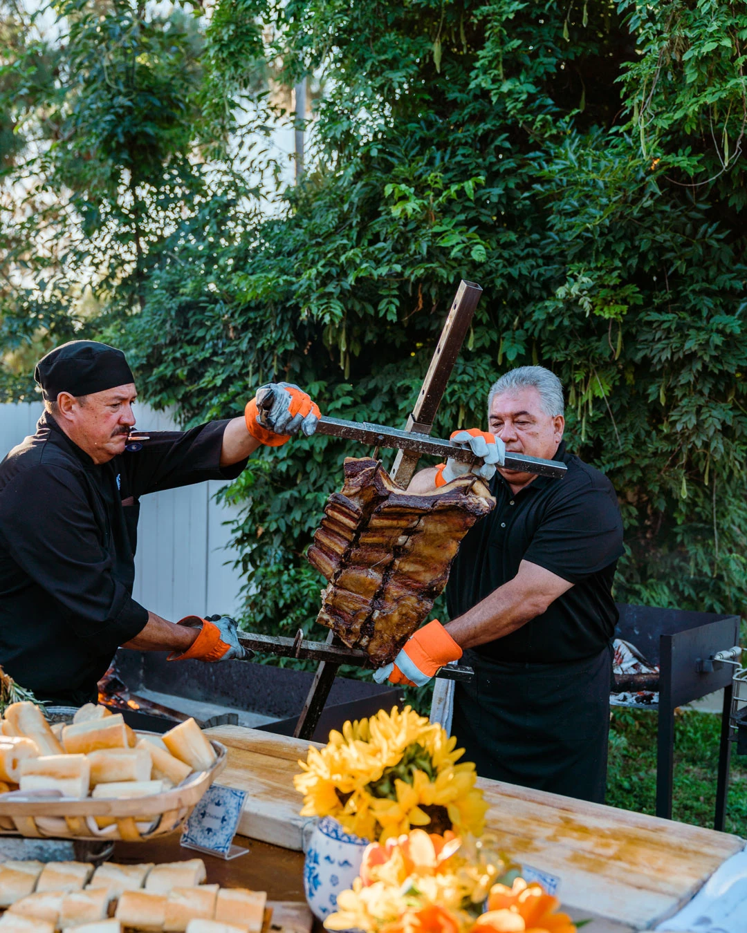 Chefs preparing food at a decorated outdoor station.