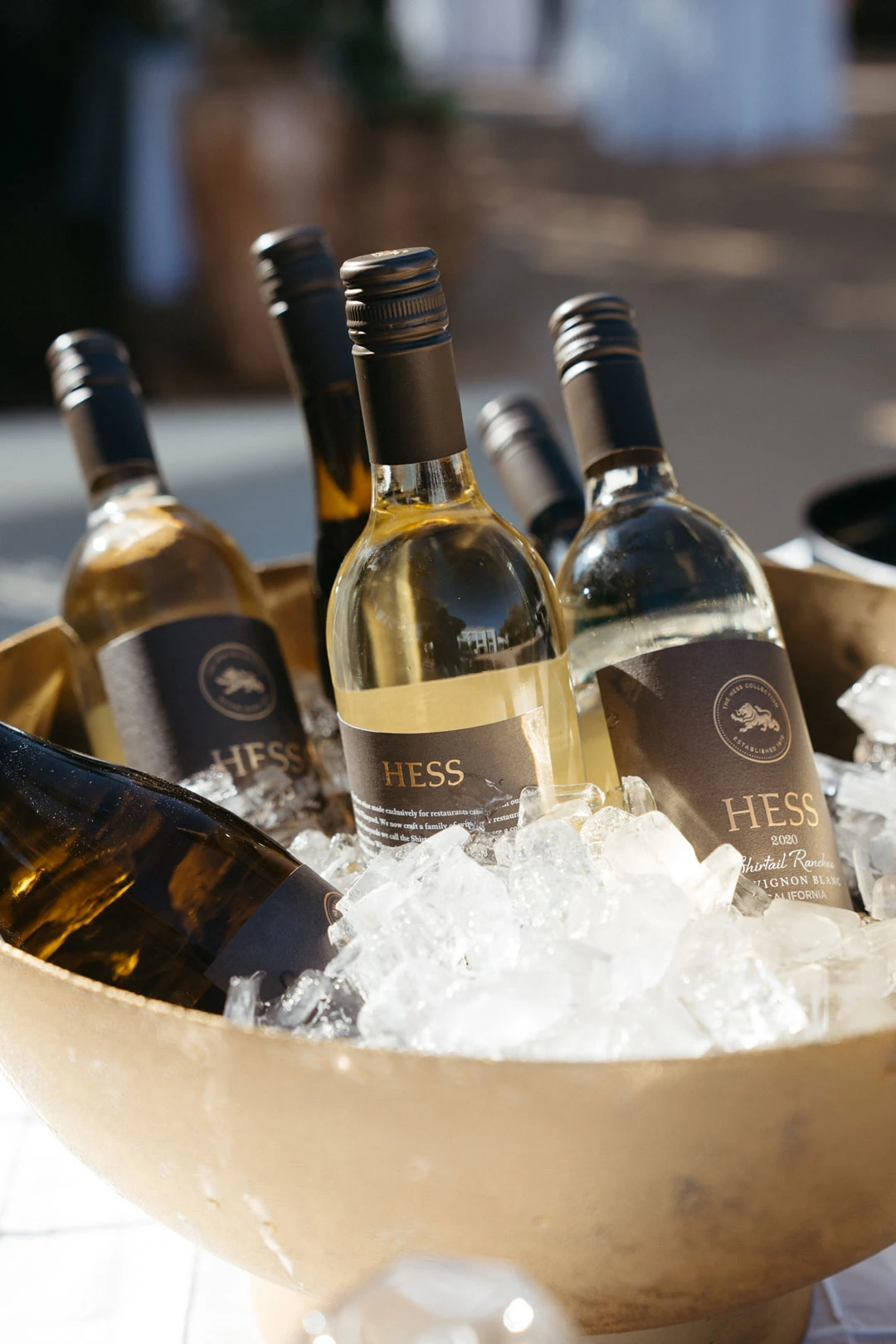 Wine bottles rest in a bowl of ice.