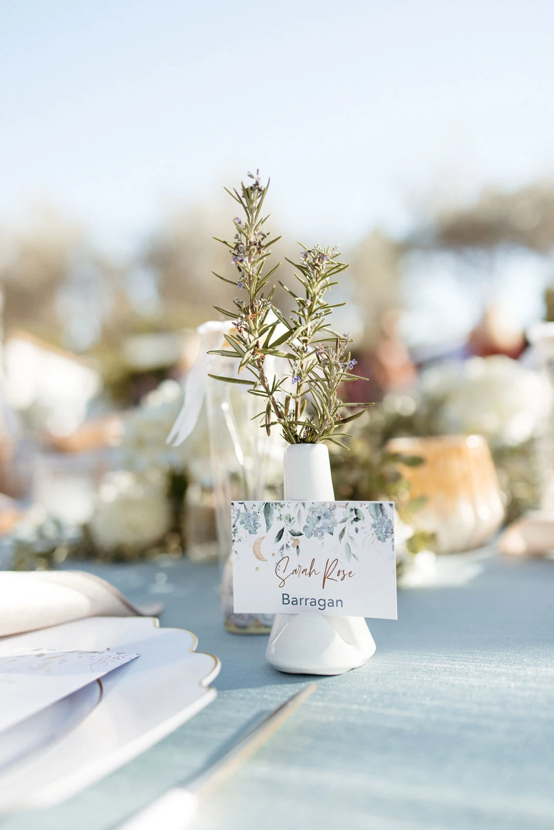 Small floral arrangement beside an outdoor place setting.