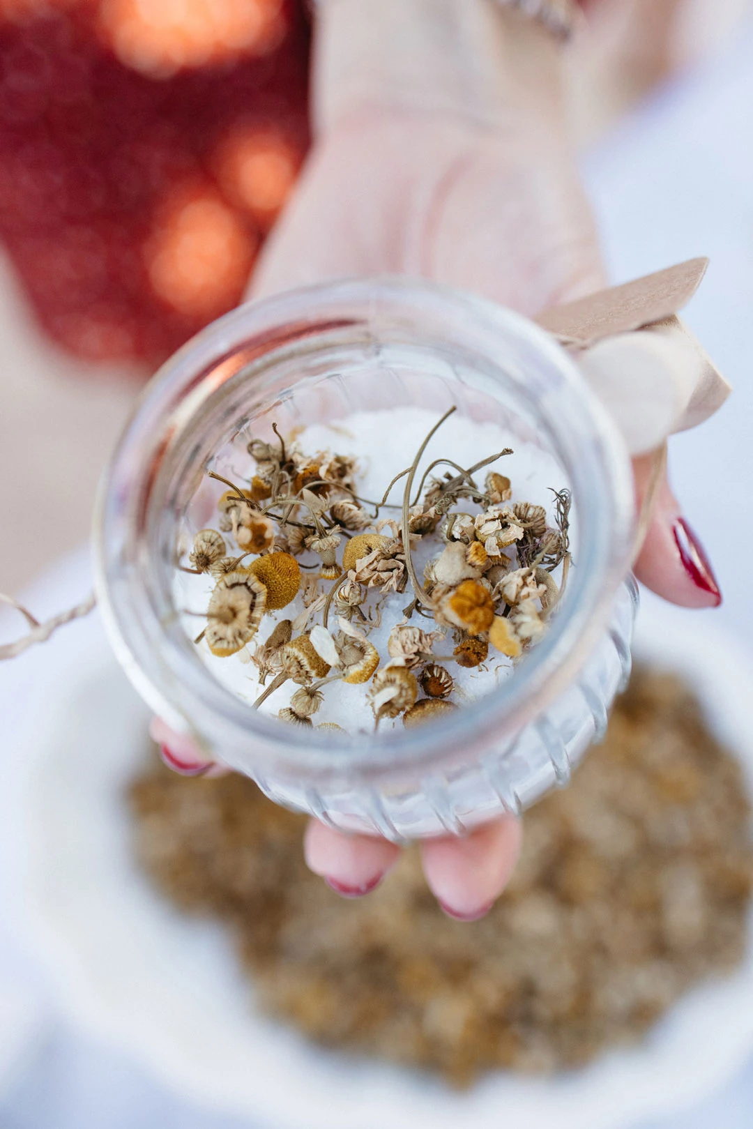 Hand holds a small bowl of dried flowers.