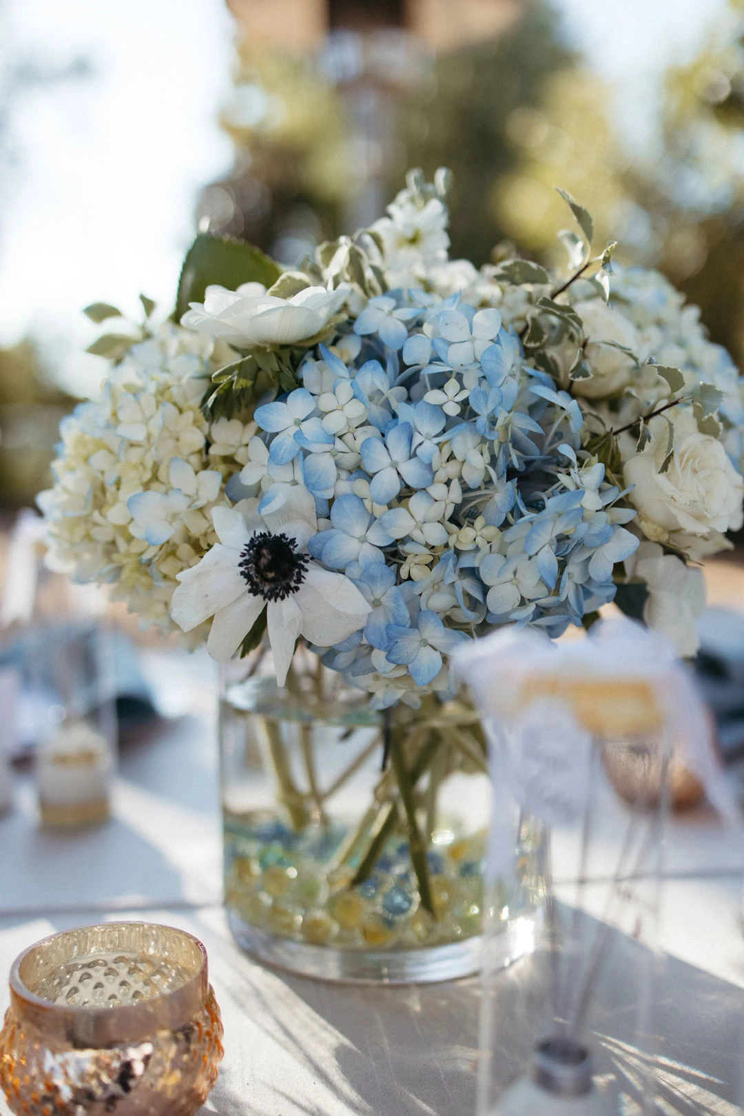 Blue and white floral arrangement on an outdoor table.