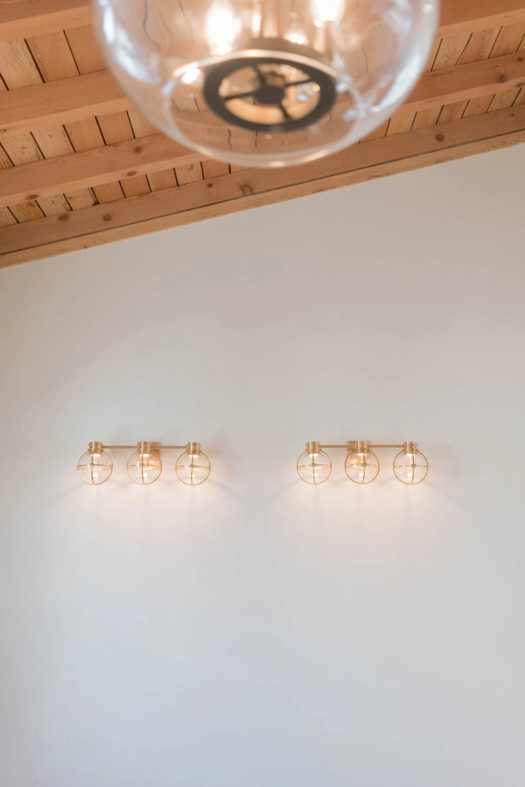 Glass pendant and wall sconces in an empty room.