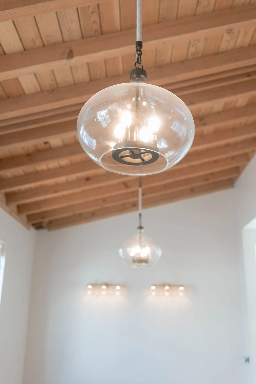 Glass pendant lighting beneath a wooden ceiling.