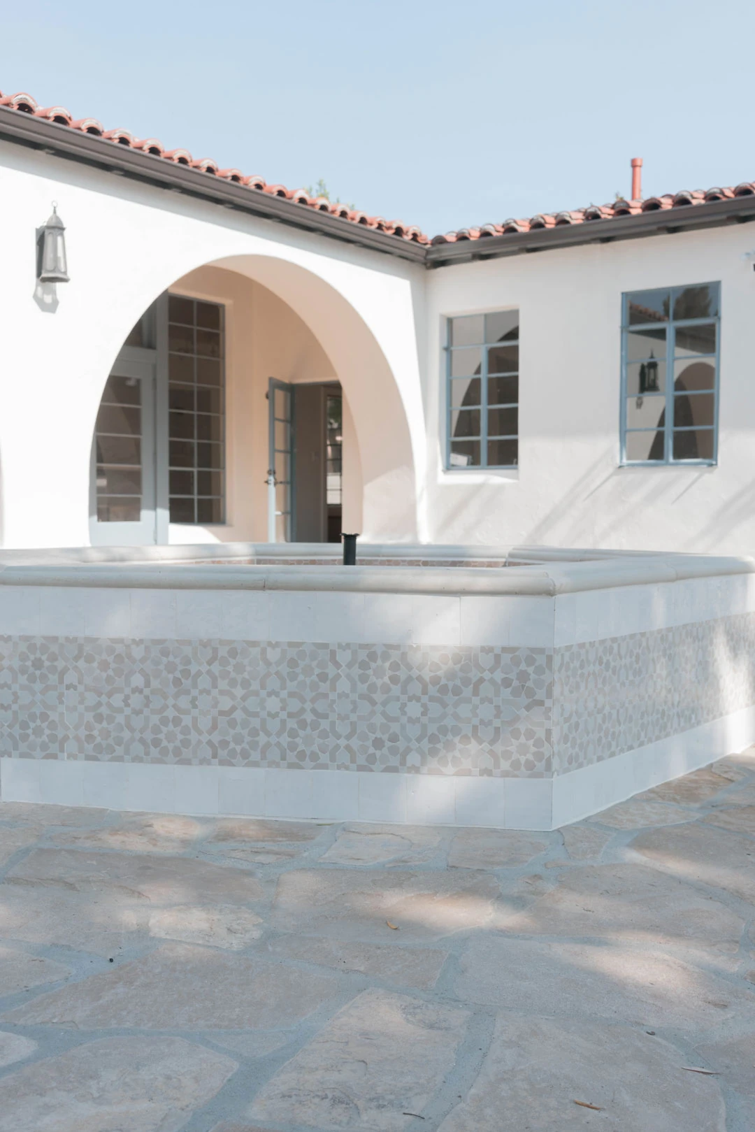 Courtyard fountain beside arched building entrances.