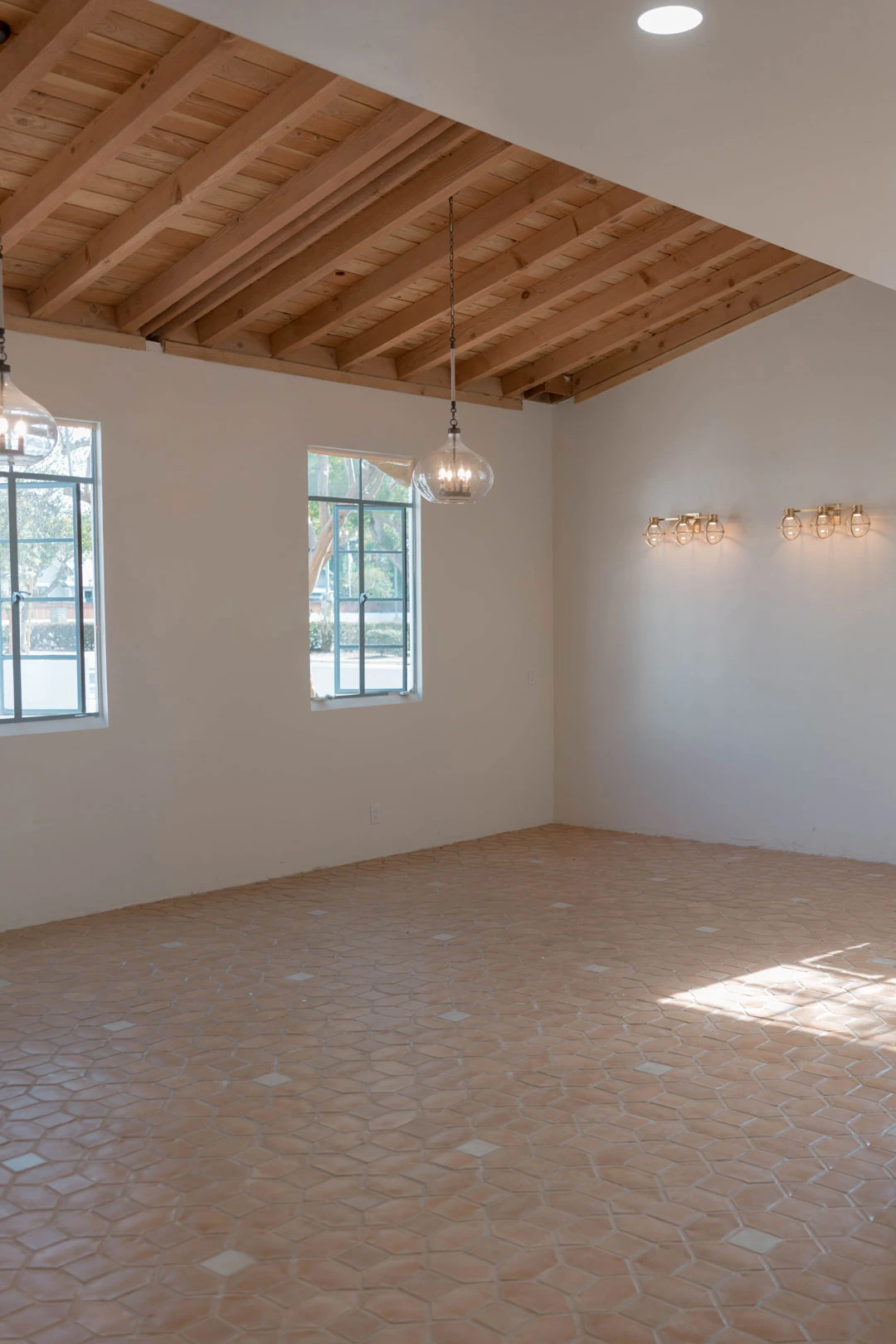 Sunlight falls across an empty room with wooden ceiling.