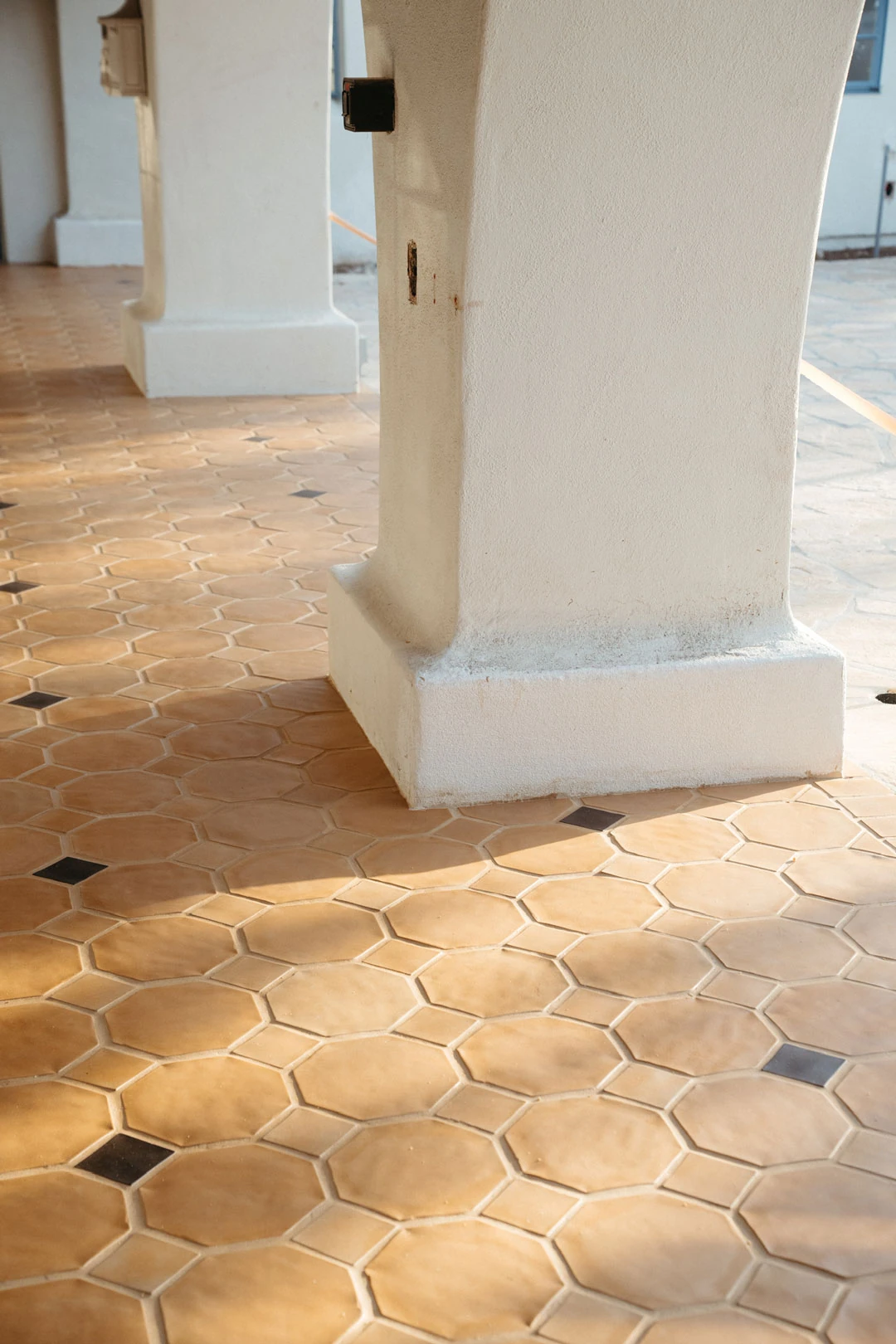 Hexagonal floor tiles beside an interior column.