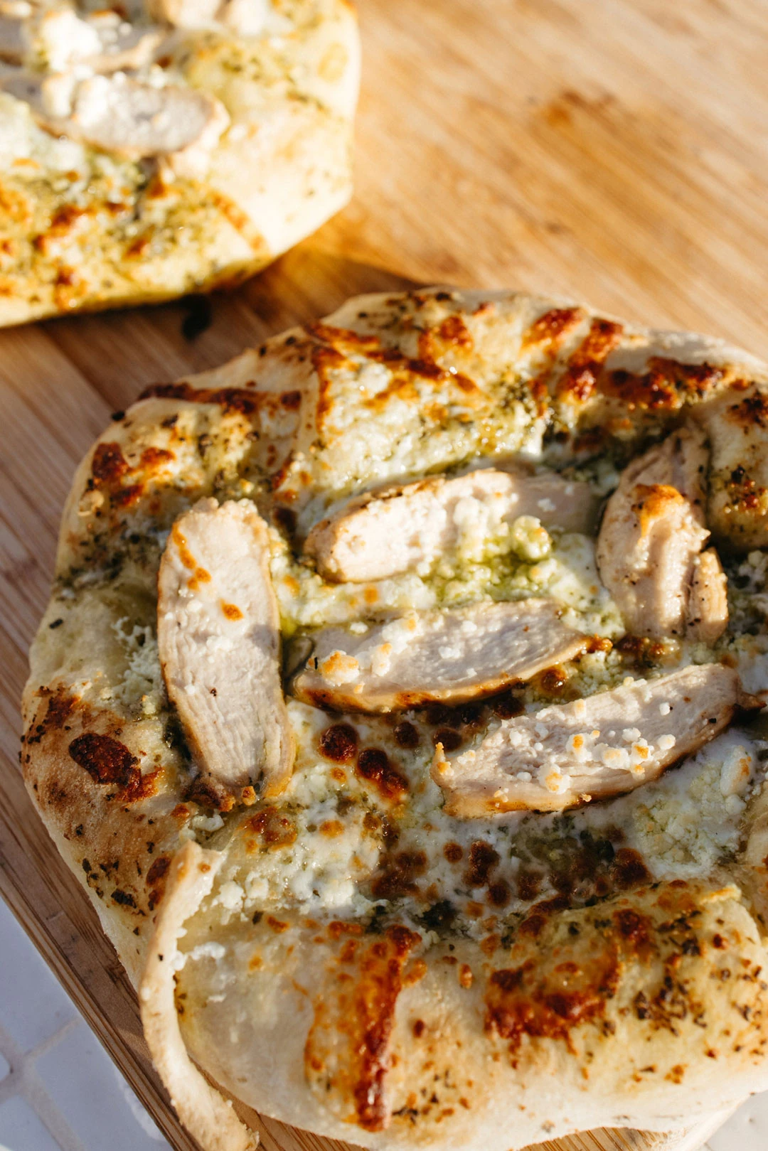 Sliced pizza with toppings on a wooden board.